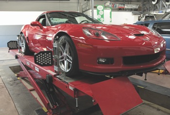 highly trained technicians handle sophisticated repairs on vehicles such as this red corvette with advanced technology systems.