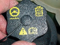 photo 4: the various symbols on this cap ­indicate that the reservoir contains power steering fluid and how to read the fluid level. the “caution” sign indicates that the owner’s manual contains a ­specific fluid ­recommendation.