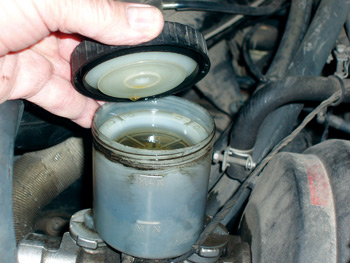 photo 2: master cylinder fluid level, color and viscosity are good indicators of overall hydraulic system condition. a fluid stain at the brake booster interface usually indicates leakage through the master cylinder rear seal. 