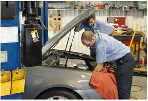 Employees work on a car Tuesday morning at Kansas Auto Repair in Newton. The company has been looking for ways to 