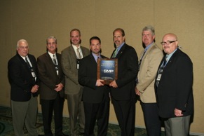 Bo Fisher, chairman of Federated Auto Parts (fourth from left) presents the Federated Outstanding Vendor of the Year Award to Standard Motor Products (L to R): Ken Wendling, Bob Kimbro, Matt Guden, Fisher, Bill Collins, Robert Frick and Alex Simmons.