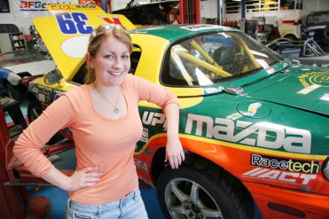 Maria Nemes, 18, stands next to her former 49er ROP auto instructor Al Angulo's Mazda Miata spec racer at the Placer High School auto shop. Thanks to the automotive technology classes, Nemes now works on the Mazda MX-5 Cup pro race team pit crew, servicing vehicles like Angulo's at races all across the country. Photo by Ben Furtado/Auburn Journal.