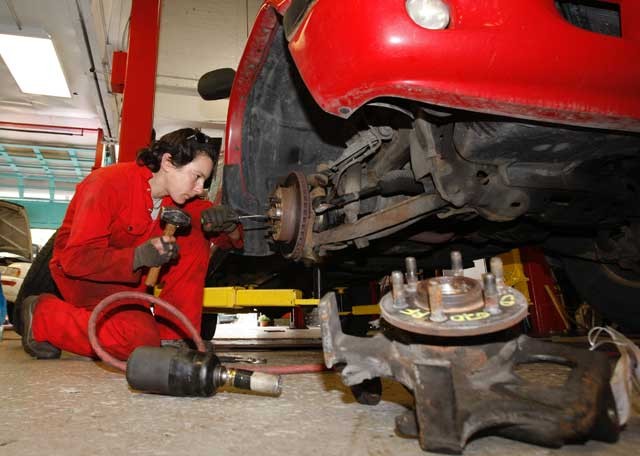 licensed mechanic maud sailland, originally from bordeaux, france, takes the tire off to pick-up truck to replace a spindle. (jack boland/toronto sun)