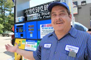 Steve Mario stands at the pump in front of his Goffstown Mobil station on North Mast Road yesterday. (GREG KWASNIK)