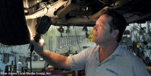 Checking for rusted brake lines, Brian McCartney inspects a car in his repair shop in Portland on Wednesday. 